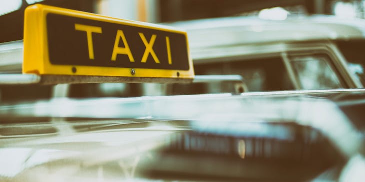 Taxi sign atop a taxi cab.