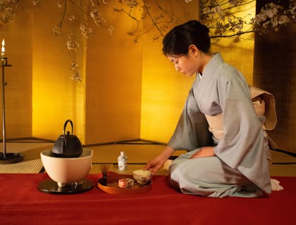 An Asian women completing a tea ceremony in a tea house.