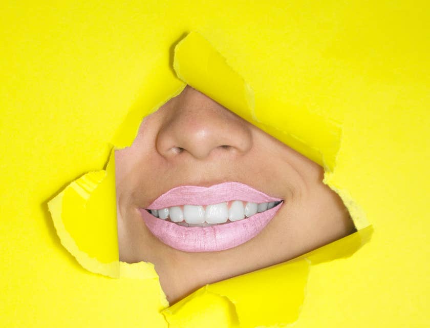 Boca con blanqueamiento dental en fondo amarillo.