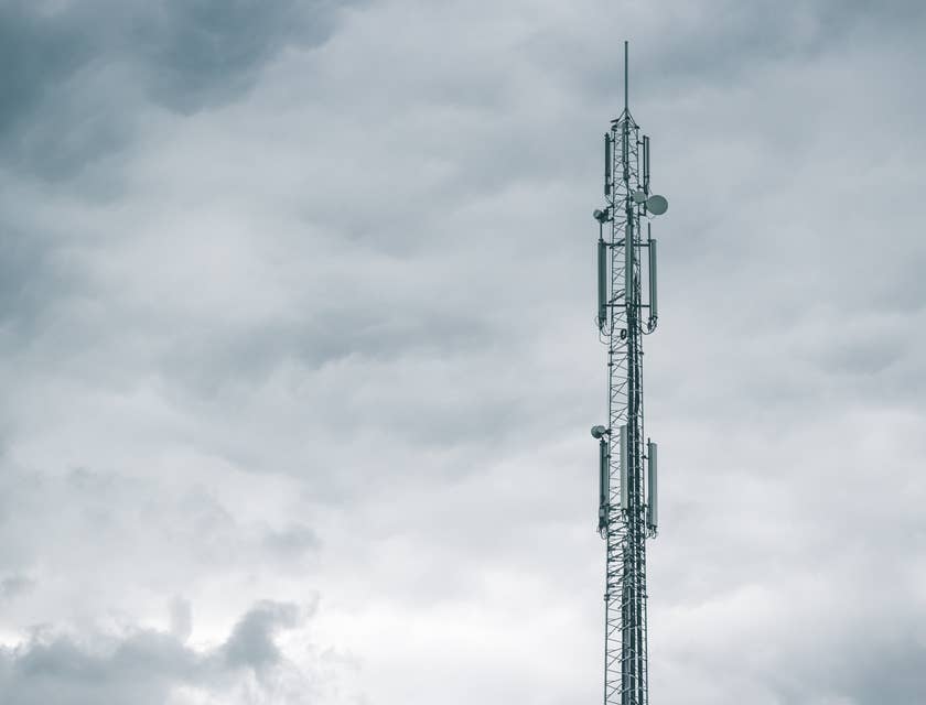 Ein Funkturm einer Telekommunikations-Firma steht vor einem wolkigen Himmel.