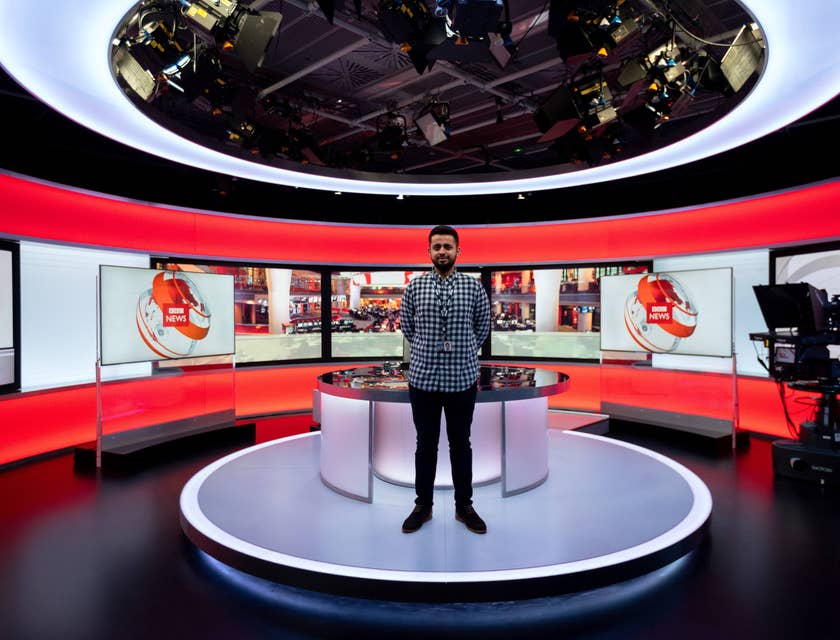 Un uomo in piedi in uno studio televisivo di proprietà di un'emittente televisiva o web tv.