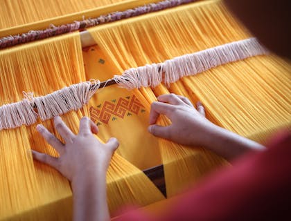 Une personne parcourant des textiles jaunes.