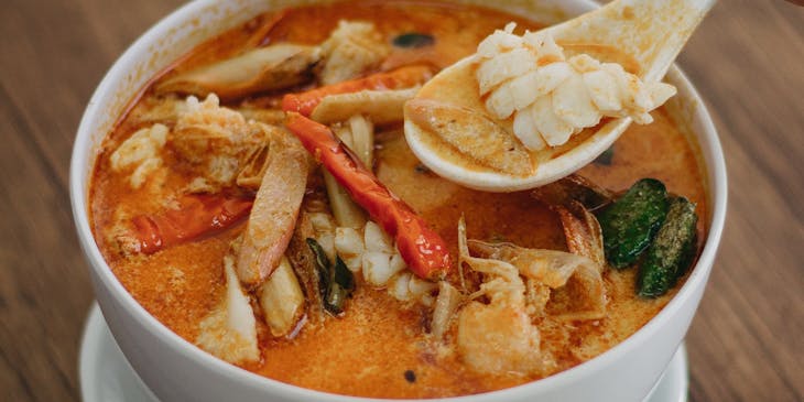 Coconut Thai soup in a white ceramic bowl.