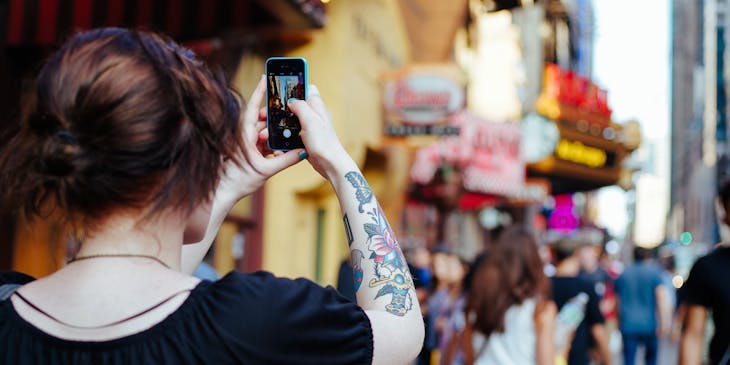 A woman on walking tour taking photo of landmarks.