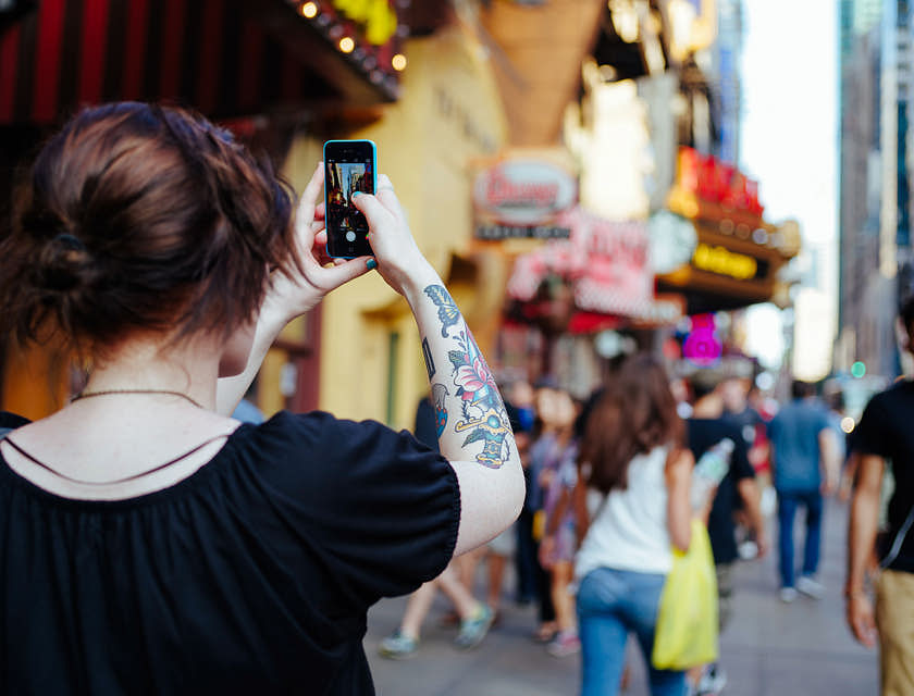 Une femme participant dans une visite guidée pédestre prenant une photo.