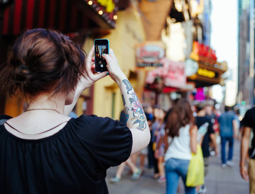 Una mujer caminando y tomándole foto a un lugar turístico en una empresa de tours..