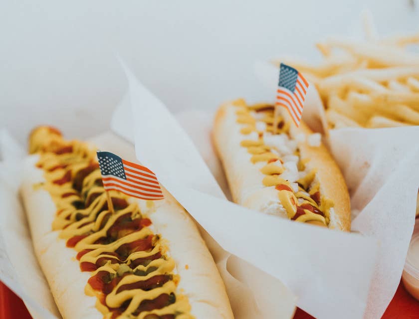 Dois cachorros-quentes com palitos de bandeira dos EUA em um restaurante tradicional americano.
