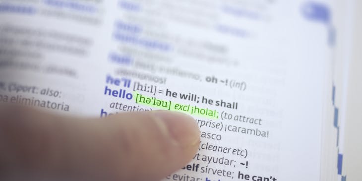 Finger pointing at dictionary translation of the highlighted word "hello".