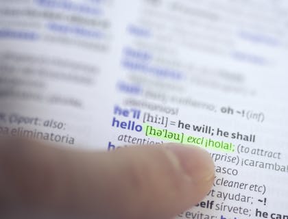 Un dedo índice apuntando en el directorio a una compañía de servicios de traducción.