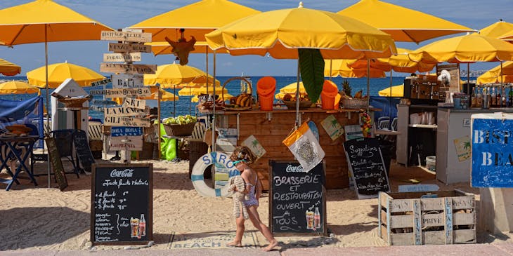 Tropical beach bar with little girl in the foreground.