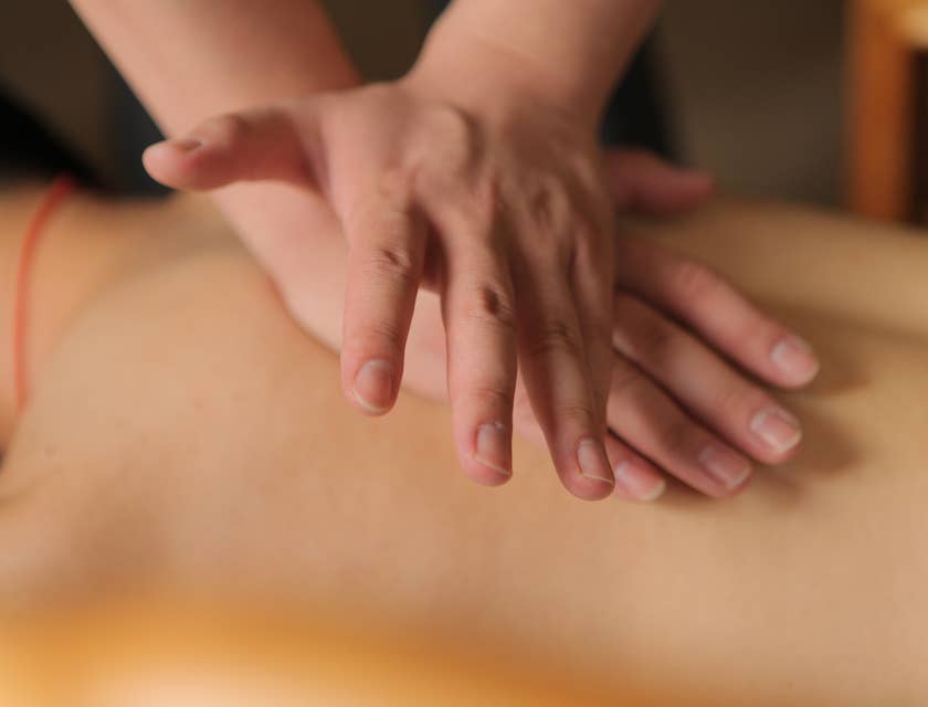Tui na practitioner applying pressure to upper back of client.
