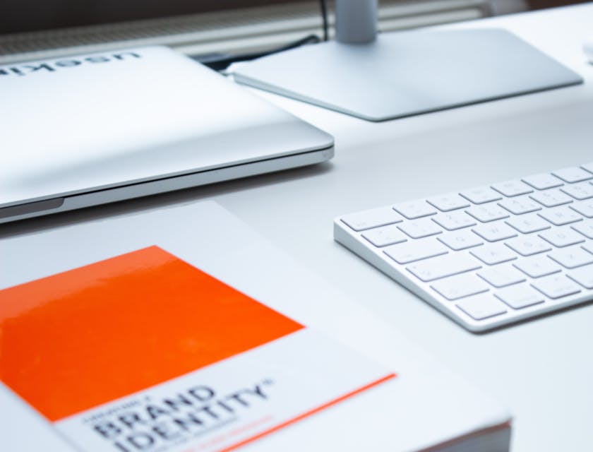 book titled brand identity next two keyboard and computer screen