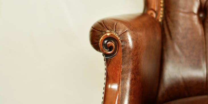 Antique armchair with brown leather upholstery