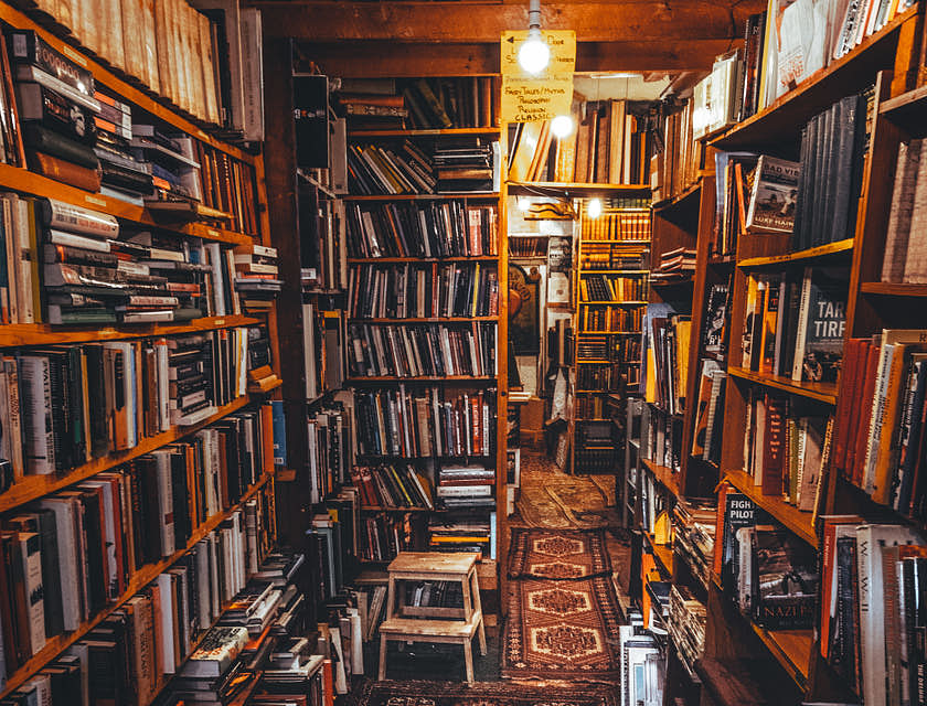Vários livros em prateleiras em um sebo.