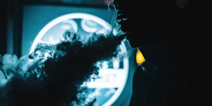 A vape smoker using product from a vape shop business.