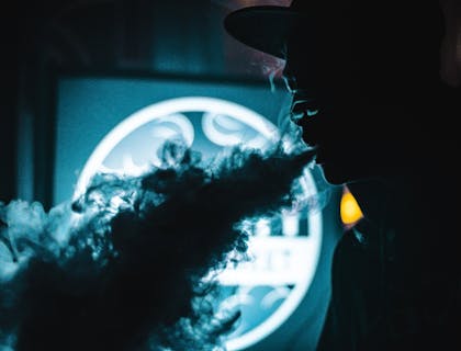 A vape smoker using product from a vape shop business.