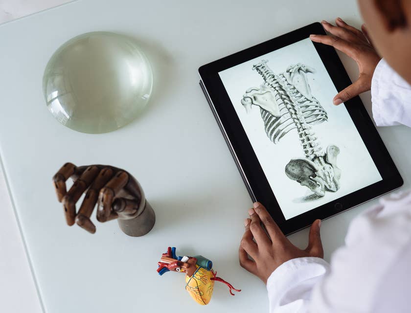 Um médico olhando para um desenho em um tablet.