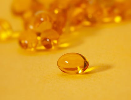 Des vitamines jaunes sur une surface jaune, dans une entreprise de vitamines et compléments alimentaires.
