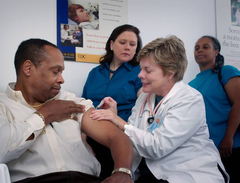 Une femme injectant le bras d'un homme dans une clinique sans rendez-vous.