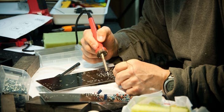 Man repairing a circuit board for water heater installation.