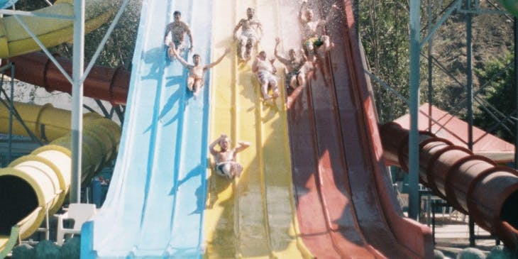 People sliding down slides sold and installed by a water slide business