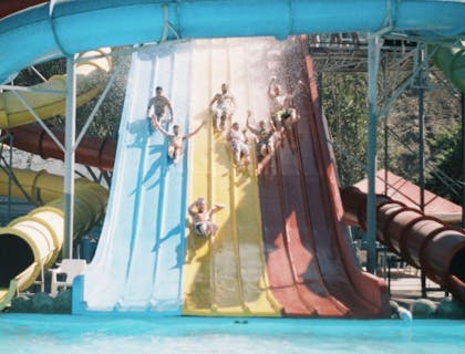 People sliding down slides sold and installed by a water slide business