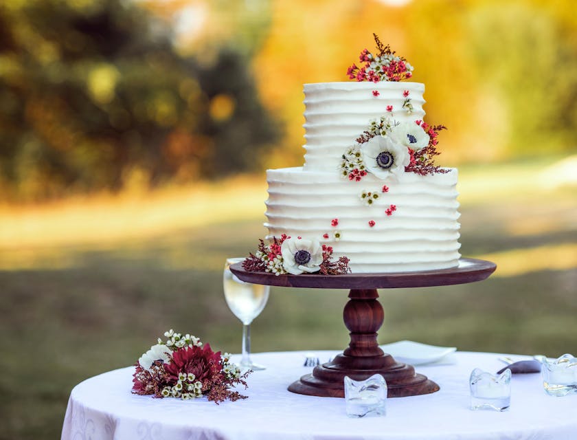 Un gâteau de mariage floral blanc et rouge.