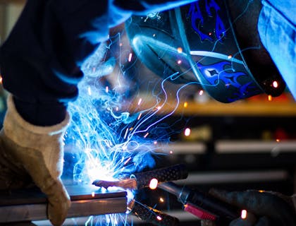 A person welding a steel frame.