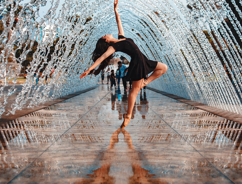 bailarina bailando sobre azulejos bajo un arco de agua en un negocio caprichoso