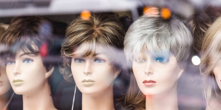 Wig store window filled with display mannequins.