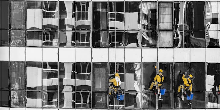 Workers cleaning glass on the exterior of the building.