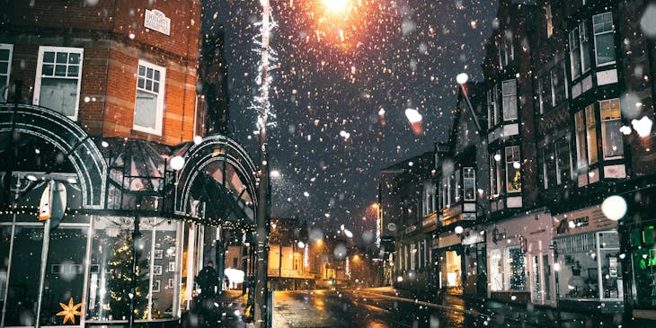 Snow falling on a city that has been winterized for the season.