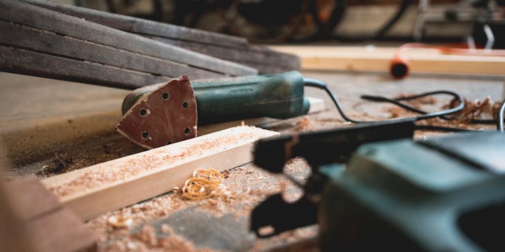Jigsaw, sander, wood, and shavings at a woodworking business.