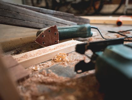 Sierra, lijadora, madera y virutas en un negocio de trabajos en madera.