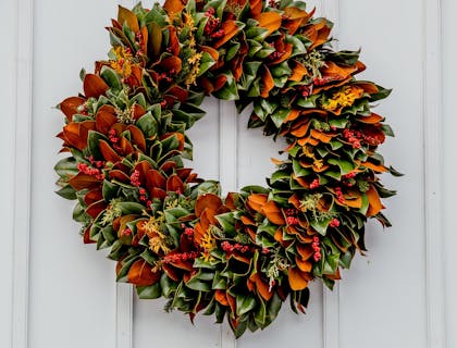 An autumn wreath hanging on a white door.