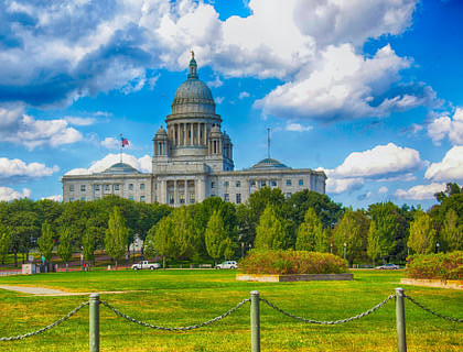 Una enorme estructura gris en medio de un área cerrada rodeada de árboles en una empresa de Rhode Island.
