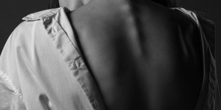 A patient exposes their spine in a consultation with a spine surgeon.