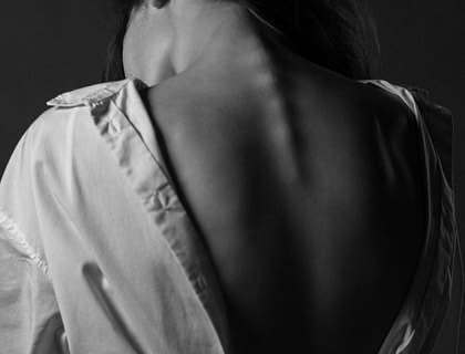 A patient exposes their spine in a consultation with a spine surgeon.