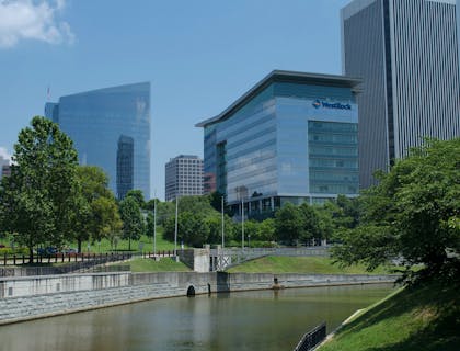 Corporate buildings lined with trees along a canal