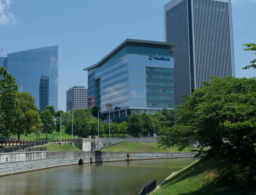 Corporate buildings lined with trees along a canal