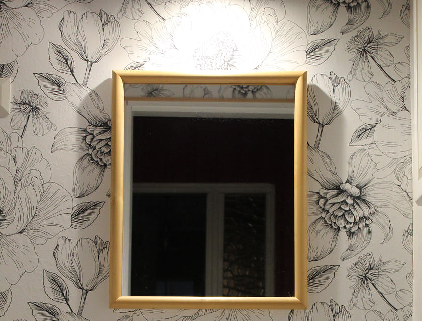 Papel de parede floral colado na parede de um banheiro.