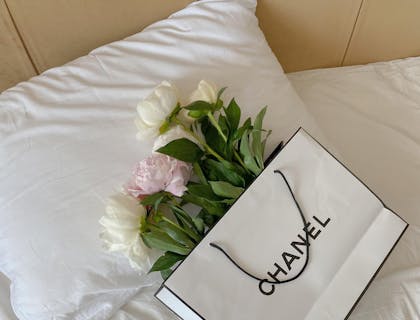 A gift bag with the two-syllable brand name "Chanel" displayed on it.